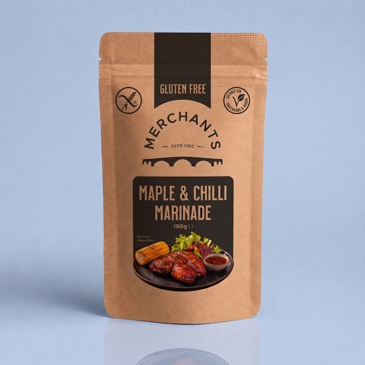 A stand-up kraft paper pouch of Merchants Maple & Chilli Marinade, 150g, shown on a light blue-gray background with a subtle reflection below.