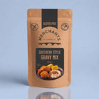 A stand-up pouch of Merchants Southern Style Gravy Mix, 150g, on a light blue background with a soft reflection below. The packaging is brown kraft paper with black and beige graphics.